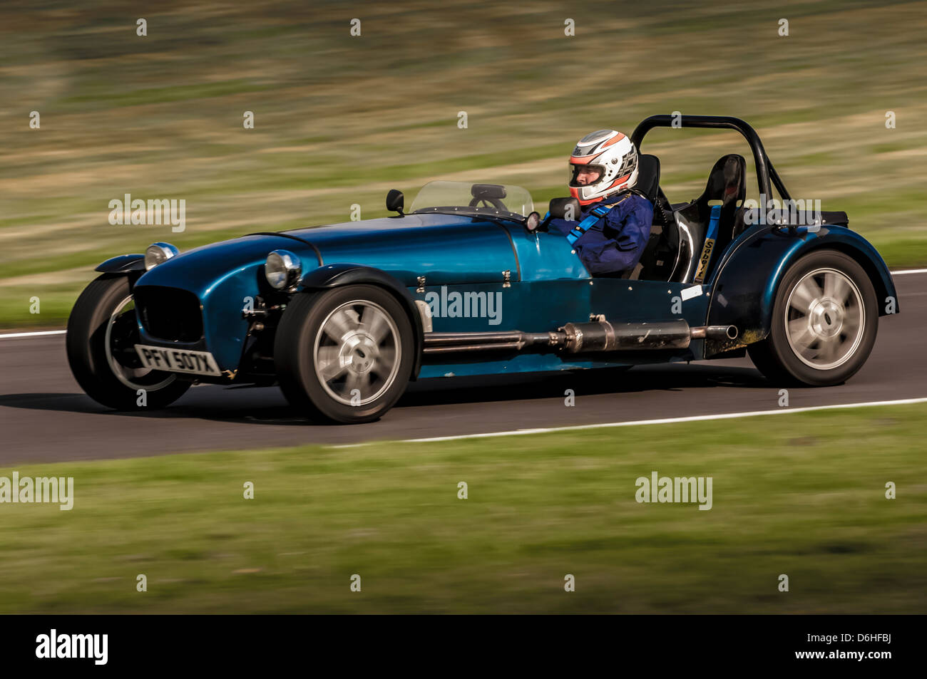 Seitenansicht des blauen Caterham-Sportwagenrennens auf der Rennstrecke im Cadwell Park Stockfoto