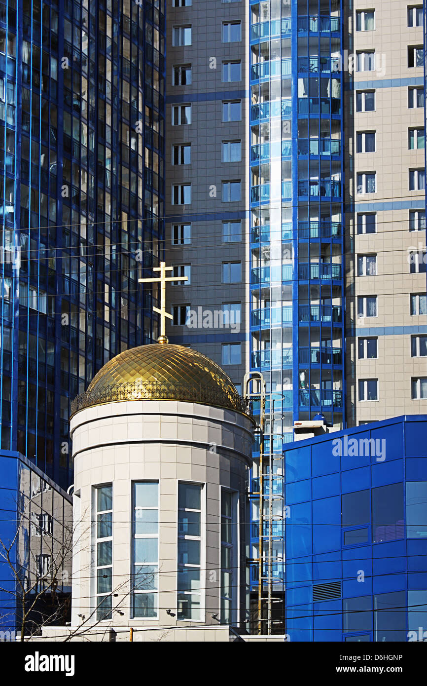 Die neue mehrstöckige Wohngebäude errichtet gemeinsam mit der orthodoxen Kirche Stockfoto