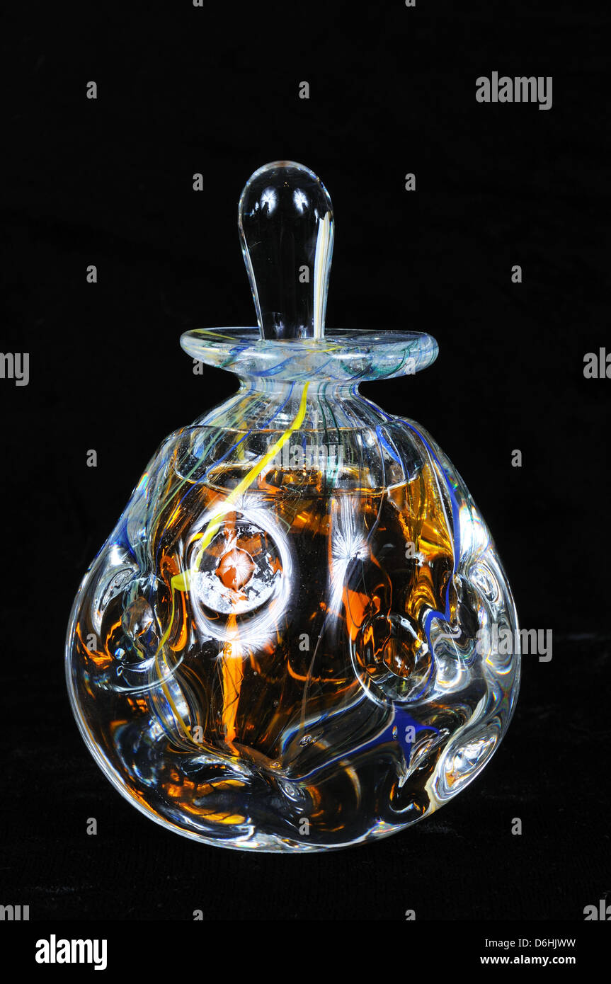 Ganzglas-Parfüm-Flasche mit Stopper vor einem schwarzen Hintergrund. Stockfoto