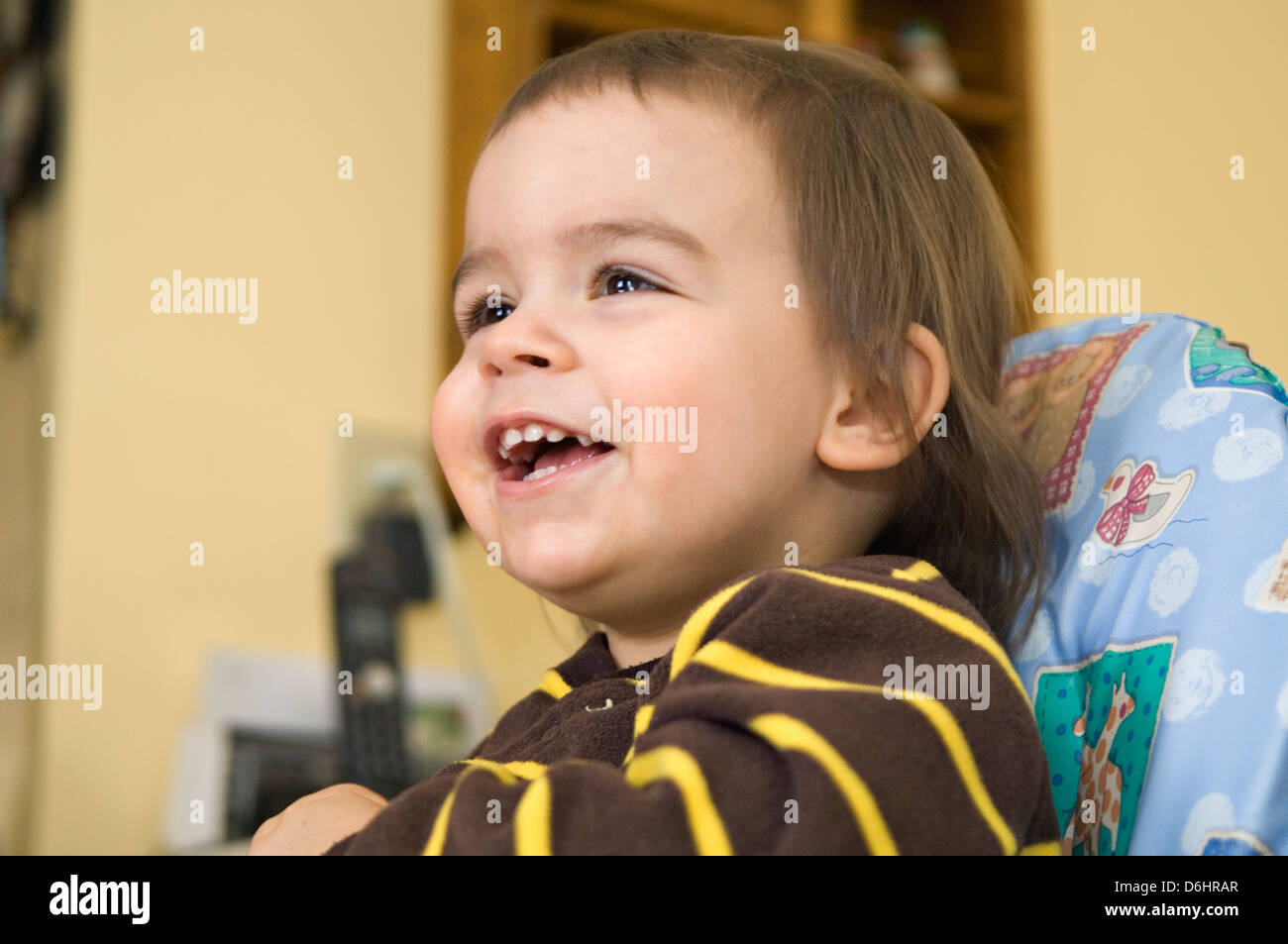 Lächelnde 22 Monate altes Kleinkind im Hochstuhl Stockfoto