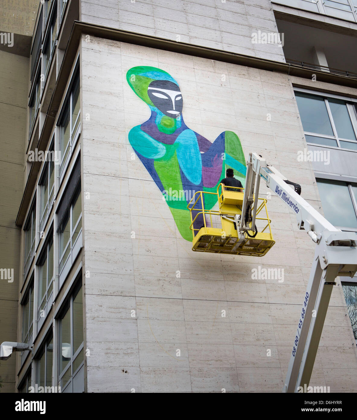 Brasilianischen Graffiti-Künstler Rimon Guimaraes steht in einem Hubwagen vor Teil der Mauer des ehemaligen Amtes von der KfW, die abgerissen werden soll, und sprüht einen riesigen Graffiti malen drauf in Frankfurt Main, Deutschland, 18. April 2013. Graffiti-Künstler aus Deutschland und Brasilien bieten Workshops in der "Graffiti-Akademie" in Zusammenarbeit mit der Kunsthalle Schirn. Foto: FRANK RUMPENHORST Stockfoto