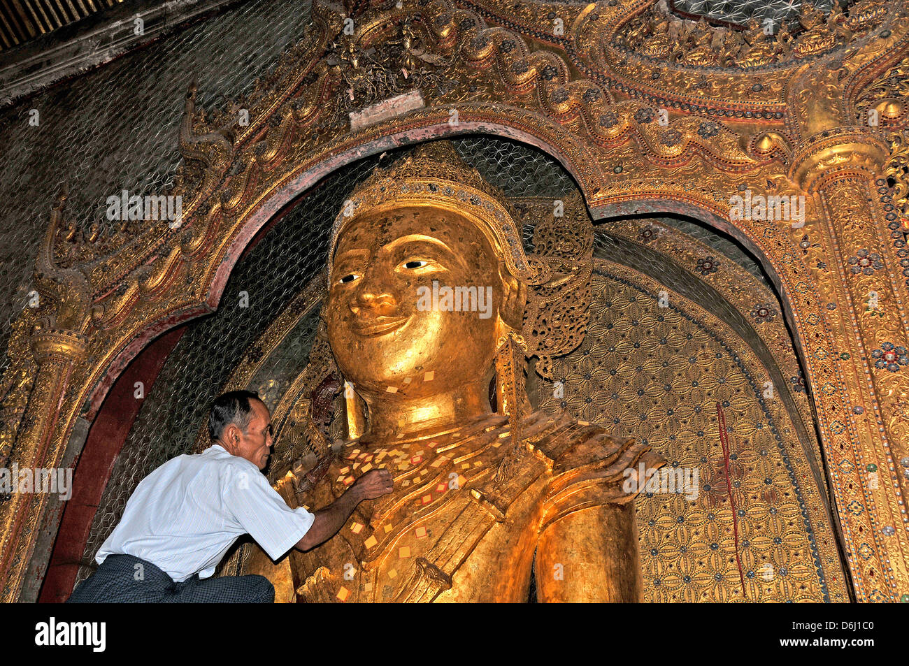 Mann posiert ein goldenes Blatt auf Buddha-Statue Taung, Pagode Inle Lake Myanmar Stockfoto