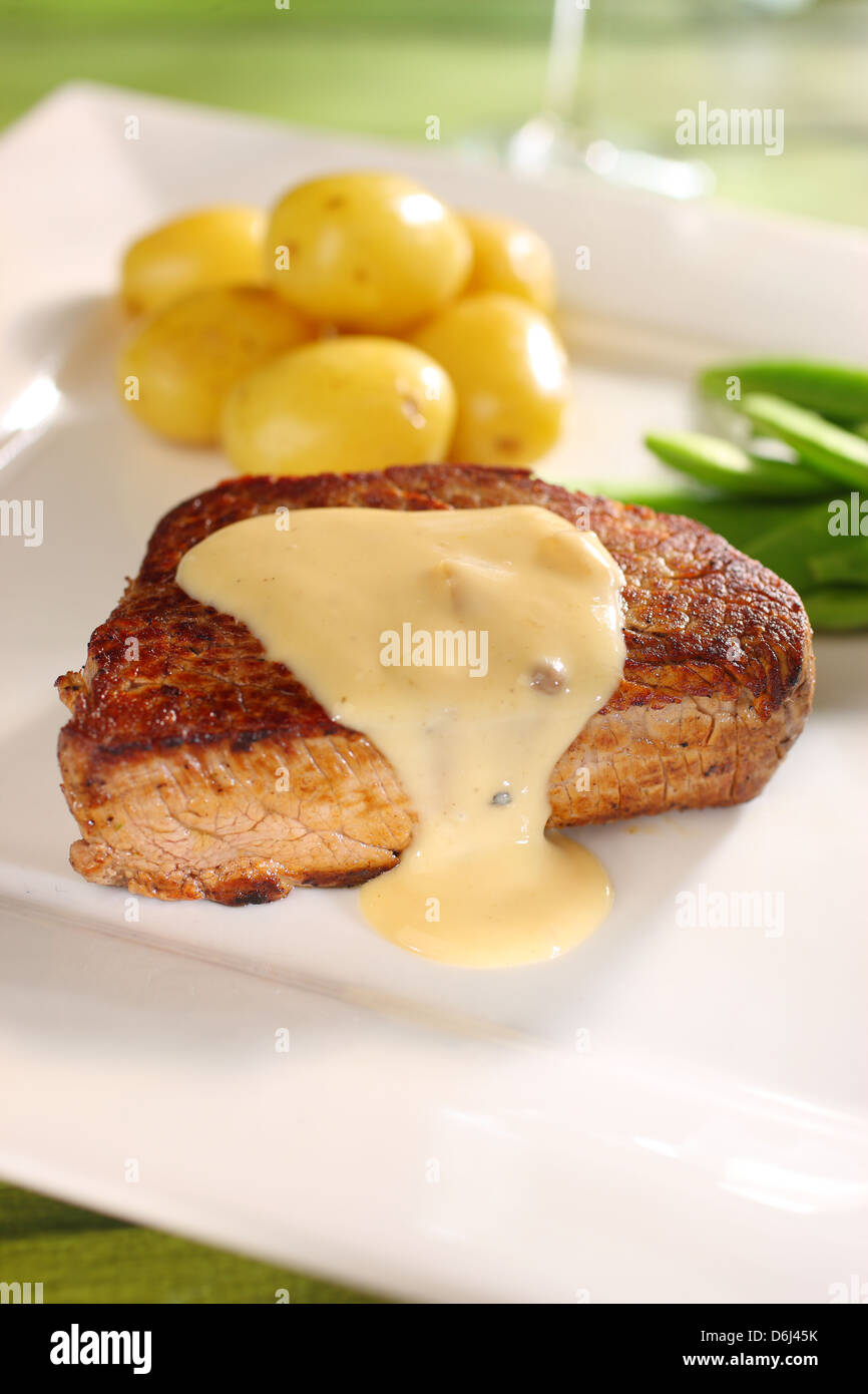 Filet Steak Rind Medaillon (Filet Mignon) mit Pfeffer sauce Butter Babykartoffeln und Zucker Zuckerschoten auf einem quadratischen weißen Teller Stockfoto