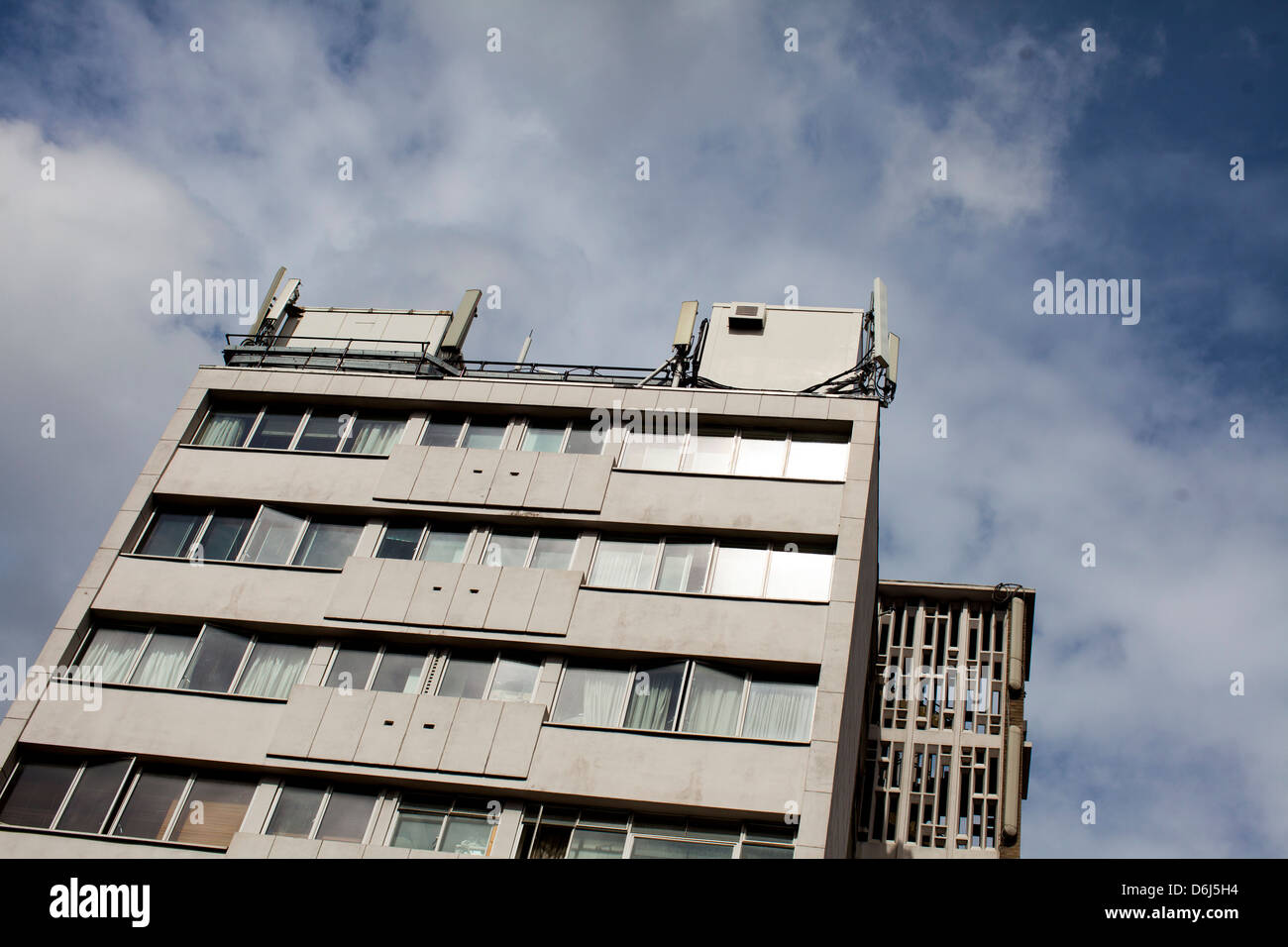 Mobilfunkmasten auf einem Bürogebäude in London, England gegen ein bewölkter Himmel. Stockfoto