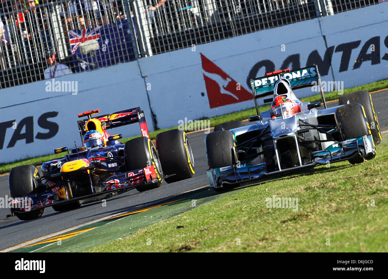 Deutsche Formel1 Rennfahrer Michael Schumacher (R) of Mercedes GP steuert sein Auto von der Strecke, wie deutsche Formel1-Fahrer Sebastian Vettel von Red Bull (L), die ihm während des australischen Formel 1 Grand Prix auf dem Albert Park Circuit in Melbourne, Australien, 18. März 2012 überholt. Foto: Jens Buettner Dpa +++(c) Dpa - Bildfunk +++ Stockfoto