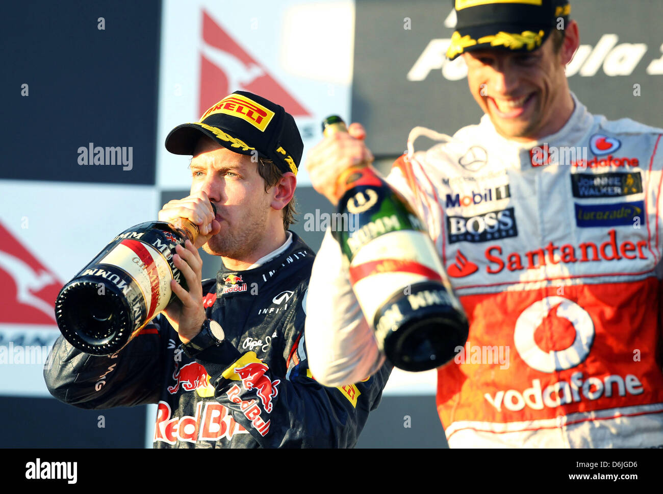 Deutsche Formel1-Fahrer Sebastian Vettel (L) trinkt Champagner auf dem Podium nach dem australischen Formel 1 Grand Prix auf dem Albert Park Circuit in Melbourne, Australien, 18. März 2012. Vettel wurde zweite. Rechts ist der Gewinner des Rennens Großbritanniens Jenson Button McLaren Mercedes. Foto: Jens Buettner Dpa +++(c) Dpa - Bildfunk +++ Stockfoto