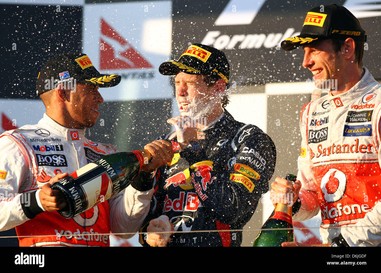 Deutsche Formel1-Fahrer Sebastian Vettel (M) von Red Bull feiert seinen zweiten Platz mit der dritten Placer, britischer Formel1-Fahrer Lewis Hamilton (L) von McLaren Mercedes und der Sieger, britische Formel1-Fahrer Jenson Button (R) of McLaren Mercedes, auf dem Podium nach dem australischen Formel 1 Grand Prix auf dem Albert Park Circuit in Melbourne, Australien, 18. März 2012. PH Stockfoto