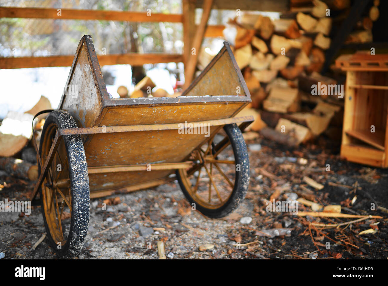 Eine einzigartige hölzerne Wagen mit einigen sah Holz im Hintergrund Stockfoto