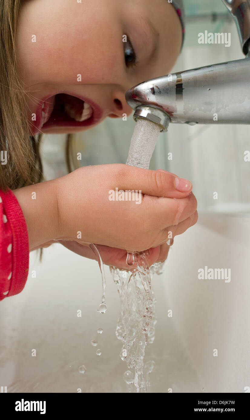 Abbildung - eine illustrierte Bild zeigt fünfjährige Amy Trinkwasser aus einem Hahn in der elterlichen Wohnung in Sieversdorf, Deutschland, 20. März 2012. World Water Day entstand im Jahr 1992 Weltkonferenz über Umwelt und Entwicklung in Rio De Janeiro. Es wird jährlich am 22. März gefeiert. Foto: Patrick Pleul Stockfoto