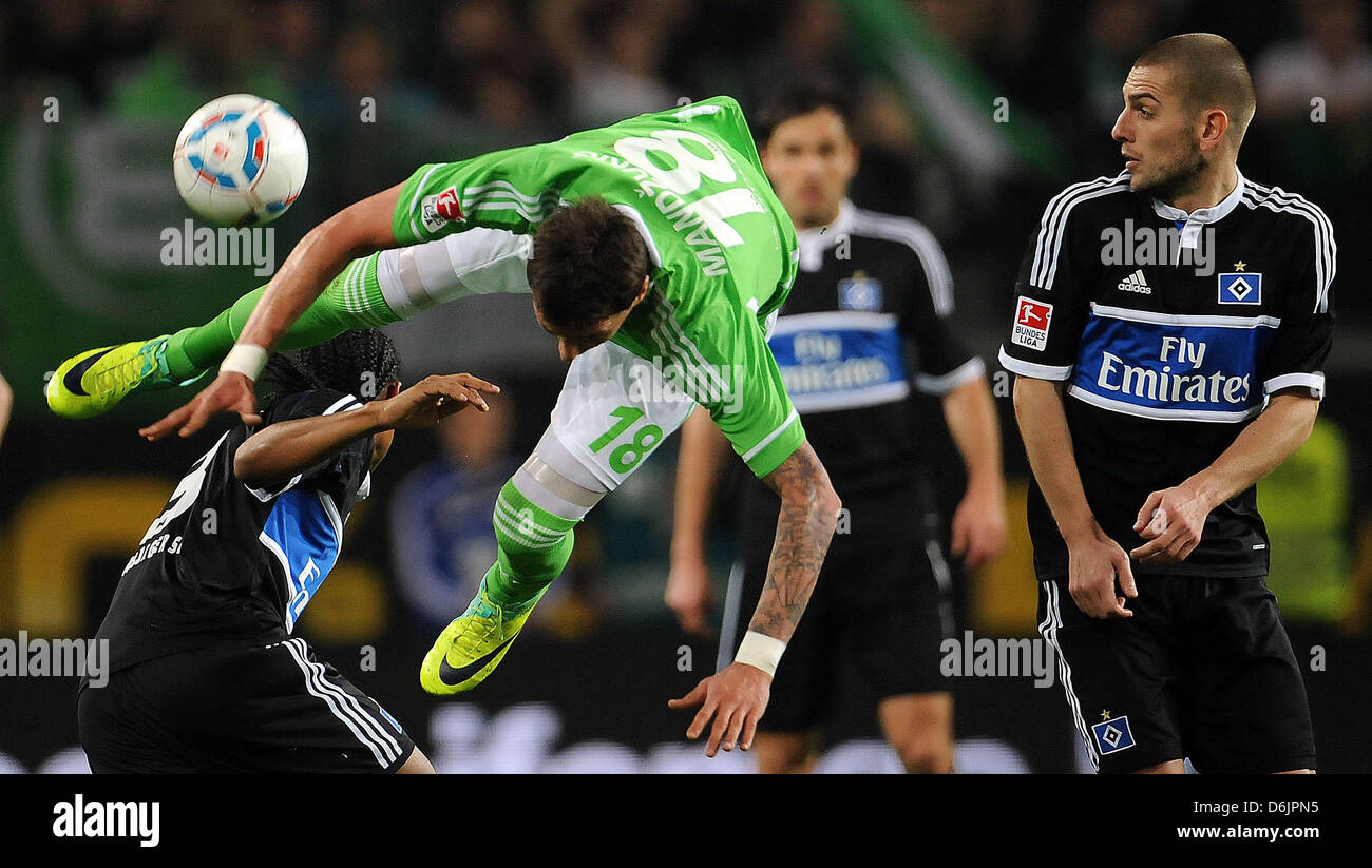 Wolfsbug des Mario Mandzukic (C) wetteifert um den Ball mit Hamburgs Michael Mancienne (L), während Hamburgs Mladen Petric während der Fußball-Bundesliga-Spiel zwischen VfL Wolfsburg und den Hamburger SV in der Volkswagen Arena in Wolfsburg, Deutschland, 23. März 2012 Uhren. Foto: Peter Steffen Stockfoto