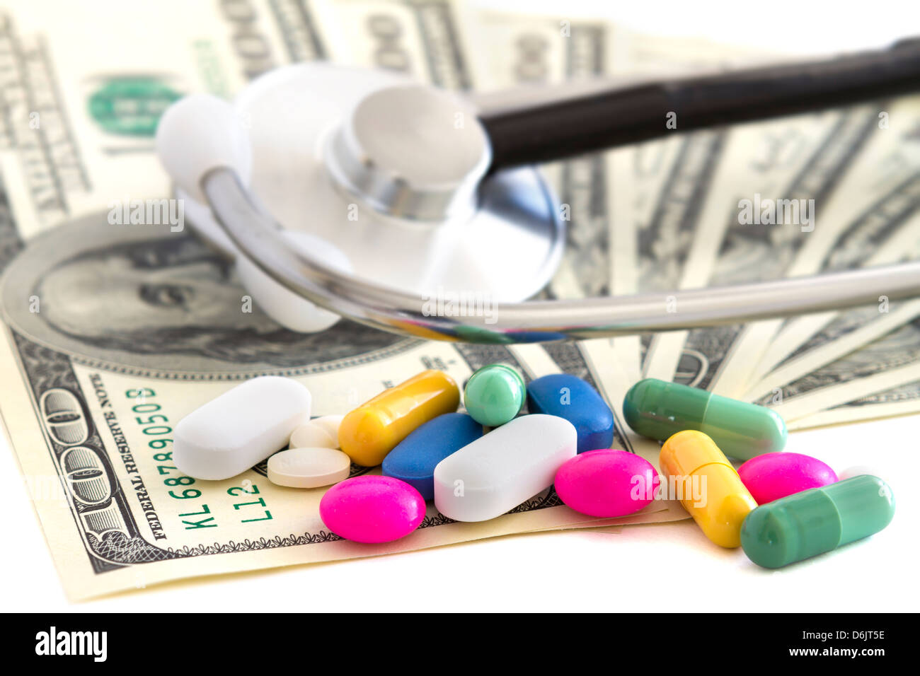Pillen, Geld und Stethoskop auf weißem Hintergrund Stockfoto