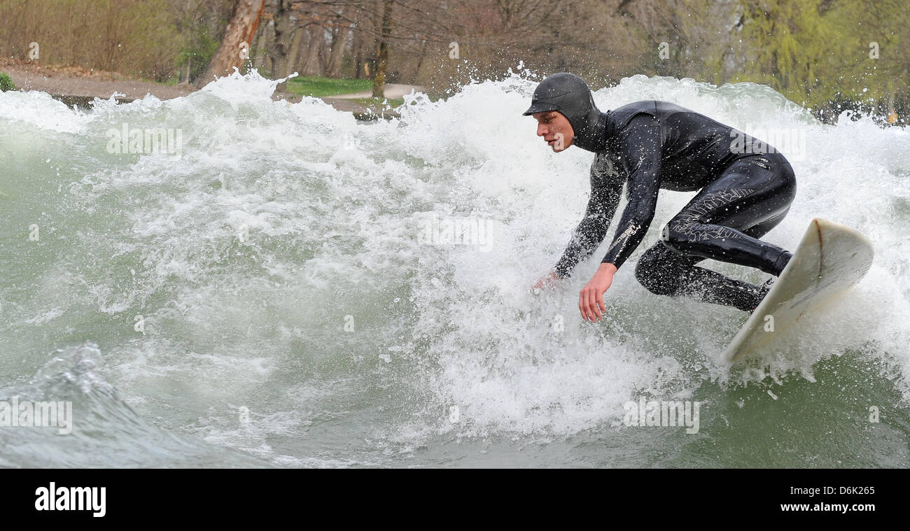 Ein Mann surft auf eine künstliche Welle des Flusses Eisbach in München, 29. März 2012. Viel Sonnenschein lockte viele Bayern ins Freie. Foto: Marc Müller Stockfoto