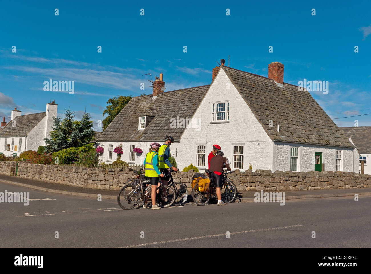 White fronted Hütten im Dorf Etal, eine Gruppe der Radfahrer im Vordergrund Stockfoto