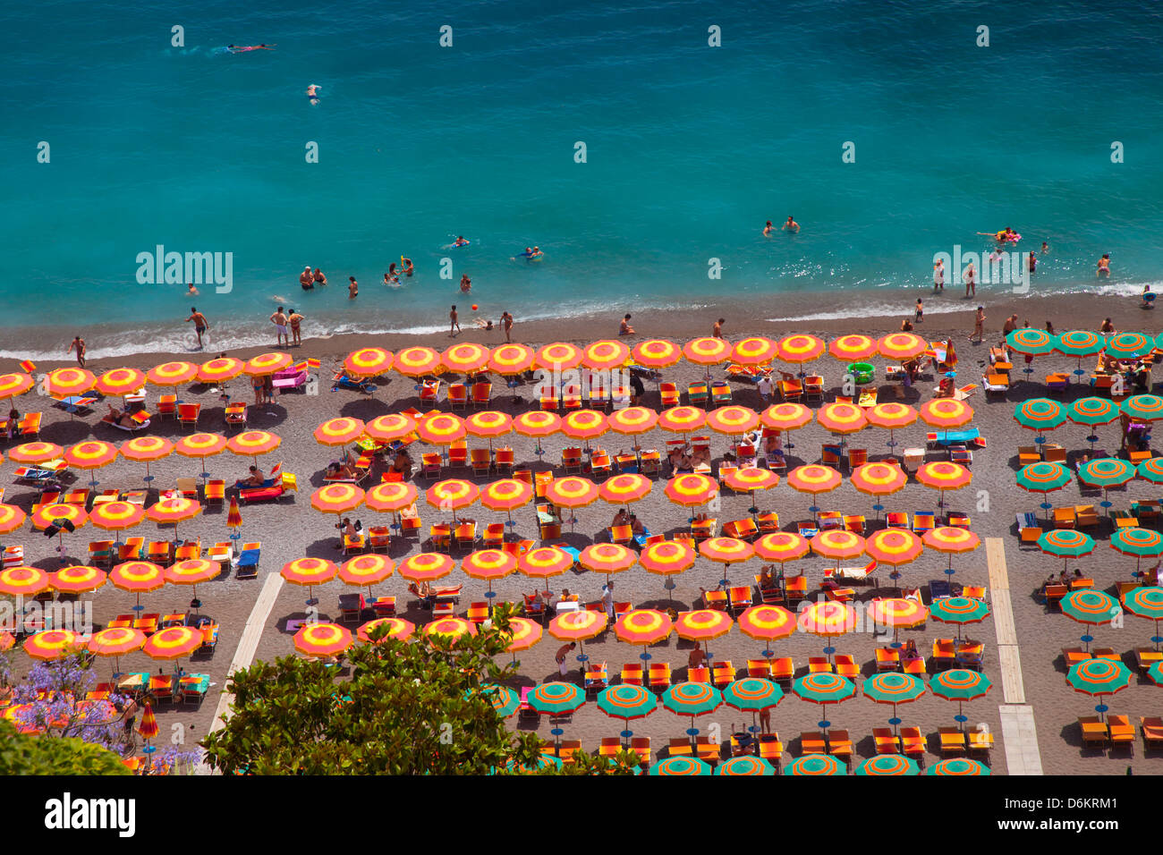 Bunte Sonnenschirme für den Strand und das türkisfarbene Wasser in Positano - entlang der Küste von Amalfi, Kampanien Italien Stockfoto