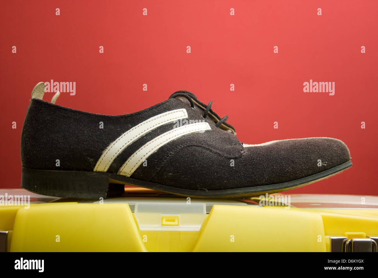 Wildlederschuhe schwarz und weiß auf rotem Grund. Stockfoto