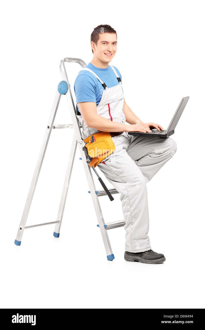 In voller Länge Portrait von ein handliches Mann mit einem Laptop sitzt auf einer Leiter, isoliert auf weißem Hintergrund Stockfoto