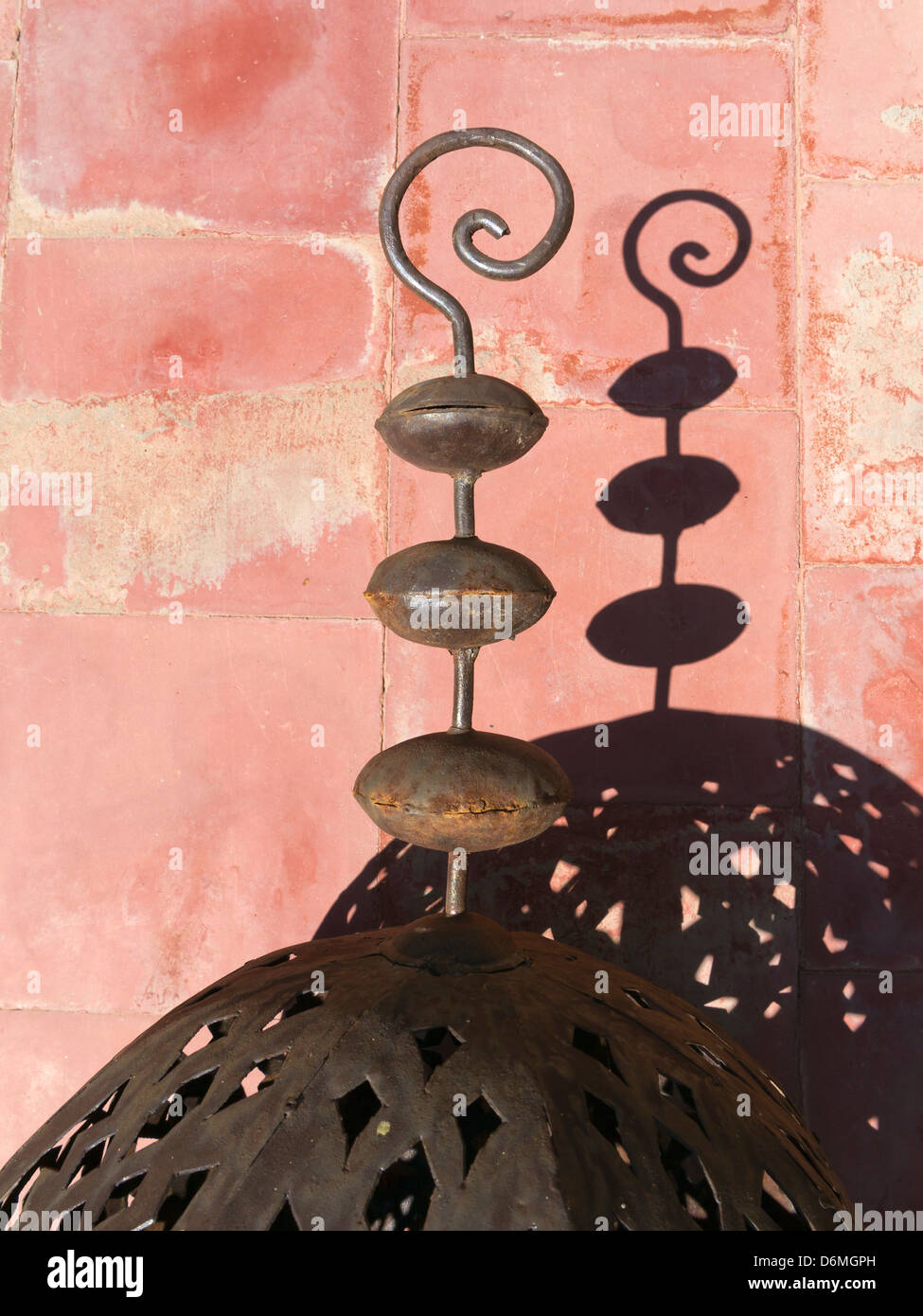 Dekorative marokkanische Schmiedekunst Hintergrund eine helle rote Farbe gesprenkelt durch Schatten wirft einen Schatten Stockfoto