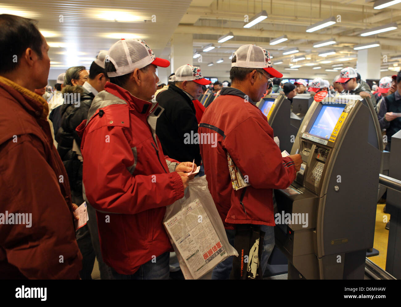 Hong Kong, China, Menschen Wette auf elektronischer Wett-terminals Stockfoto