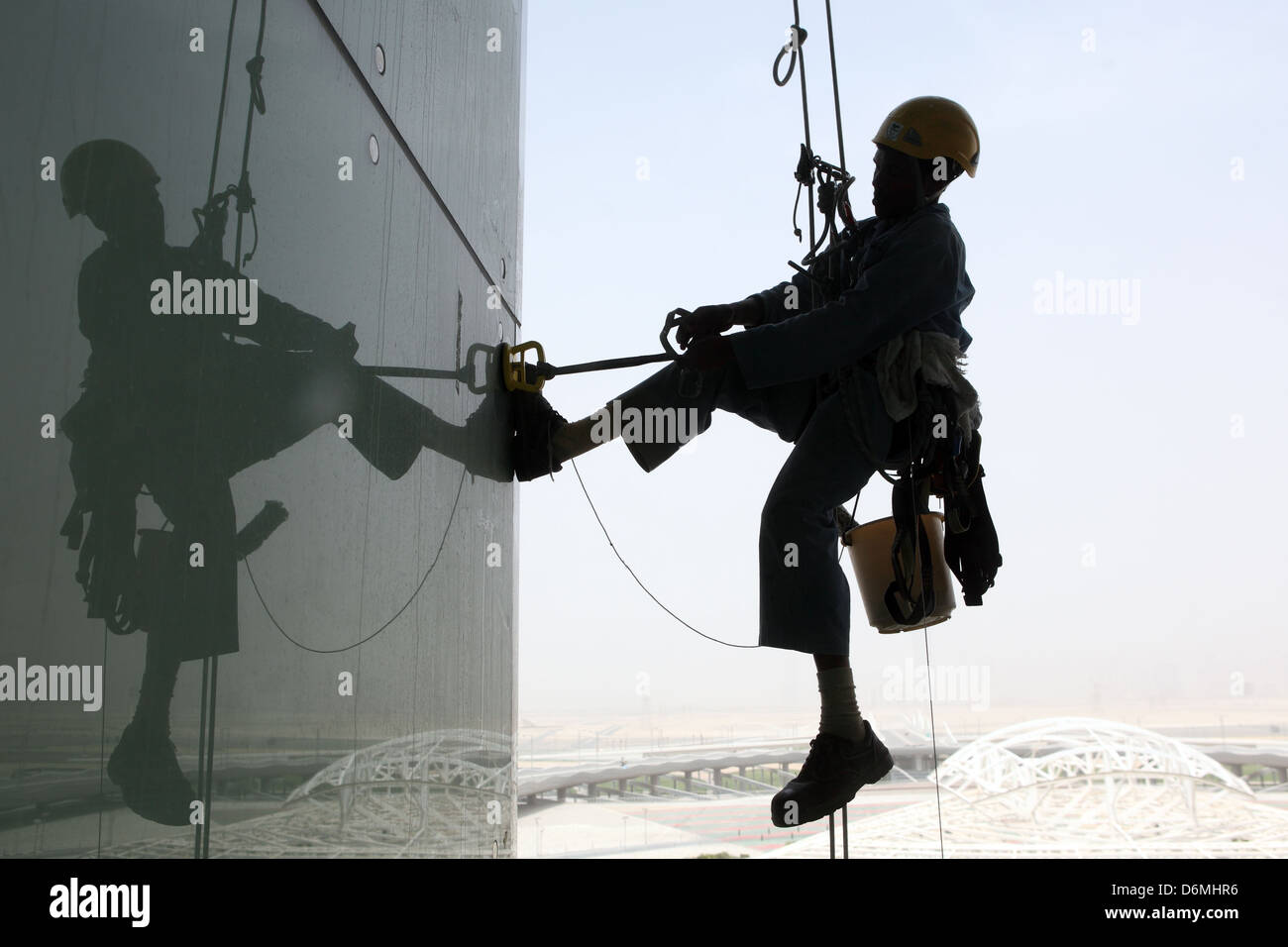Dubai, Vereinigte Arabische Emirate, Silhouette, Fensterputzer bei der Arbeit auf eine Glasfassade Stockfoto