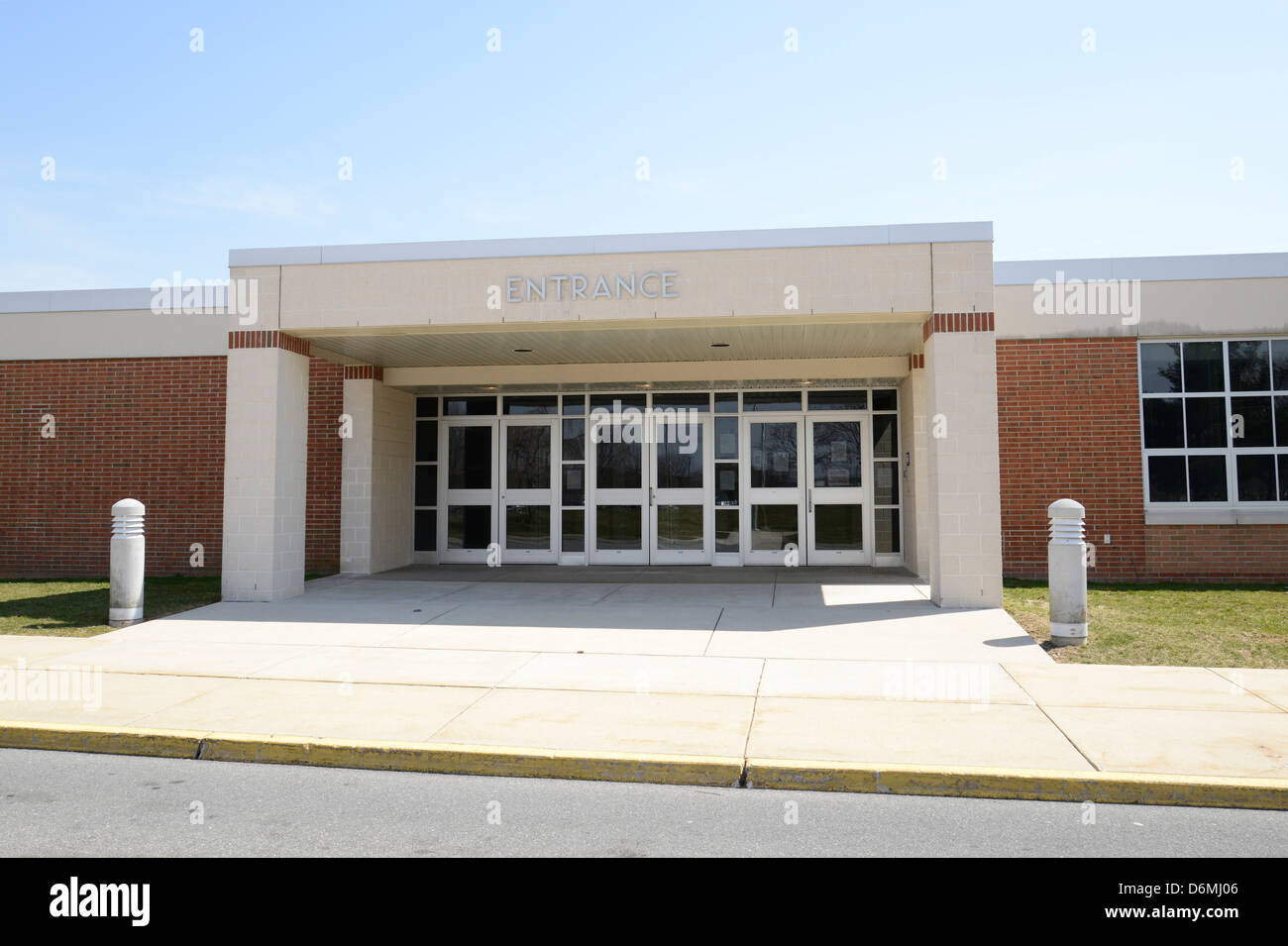 Eingang für eine moderne Schule mit einem überdachten Eingangsbereich und Bürgersteig Stockfoto