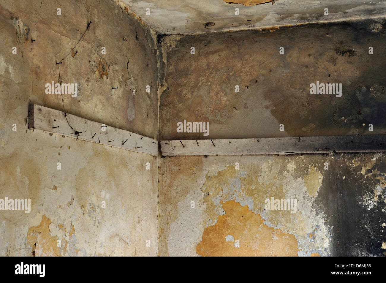 Bretter mit rostigen Nägeln an den bröckelnden Wänden verfallene verlassenen Platz. Stockfoto