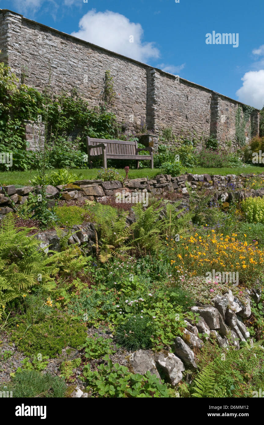 Holz Gartenbank in englischer Sprache ummauerten Garten. Stockfoto