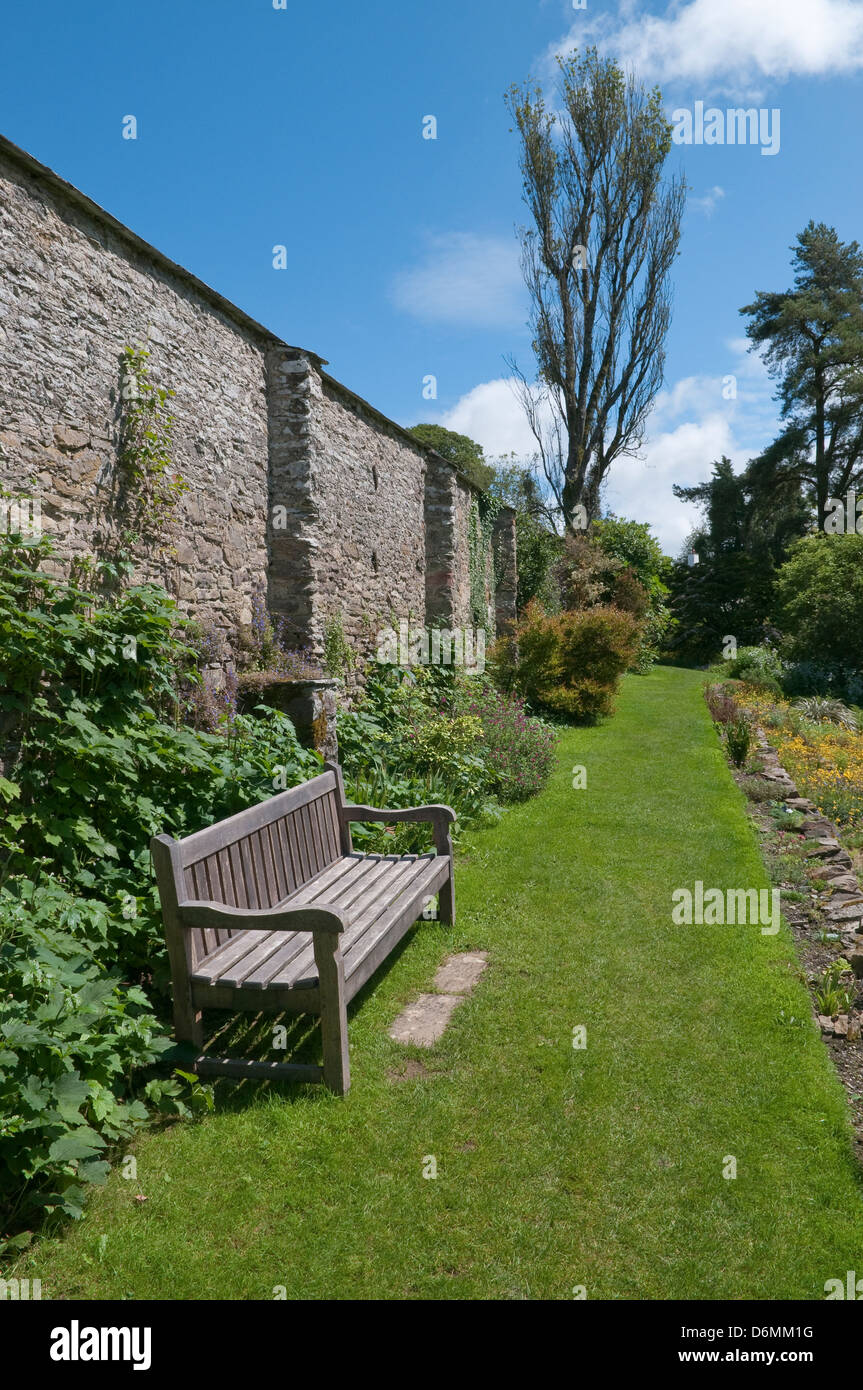 Holz Gartenbank in englischer Sprache ummauerten Garten. Stockfoto