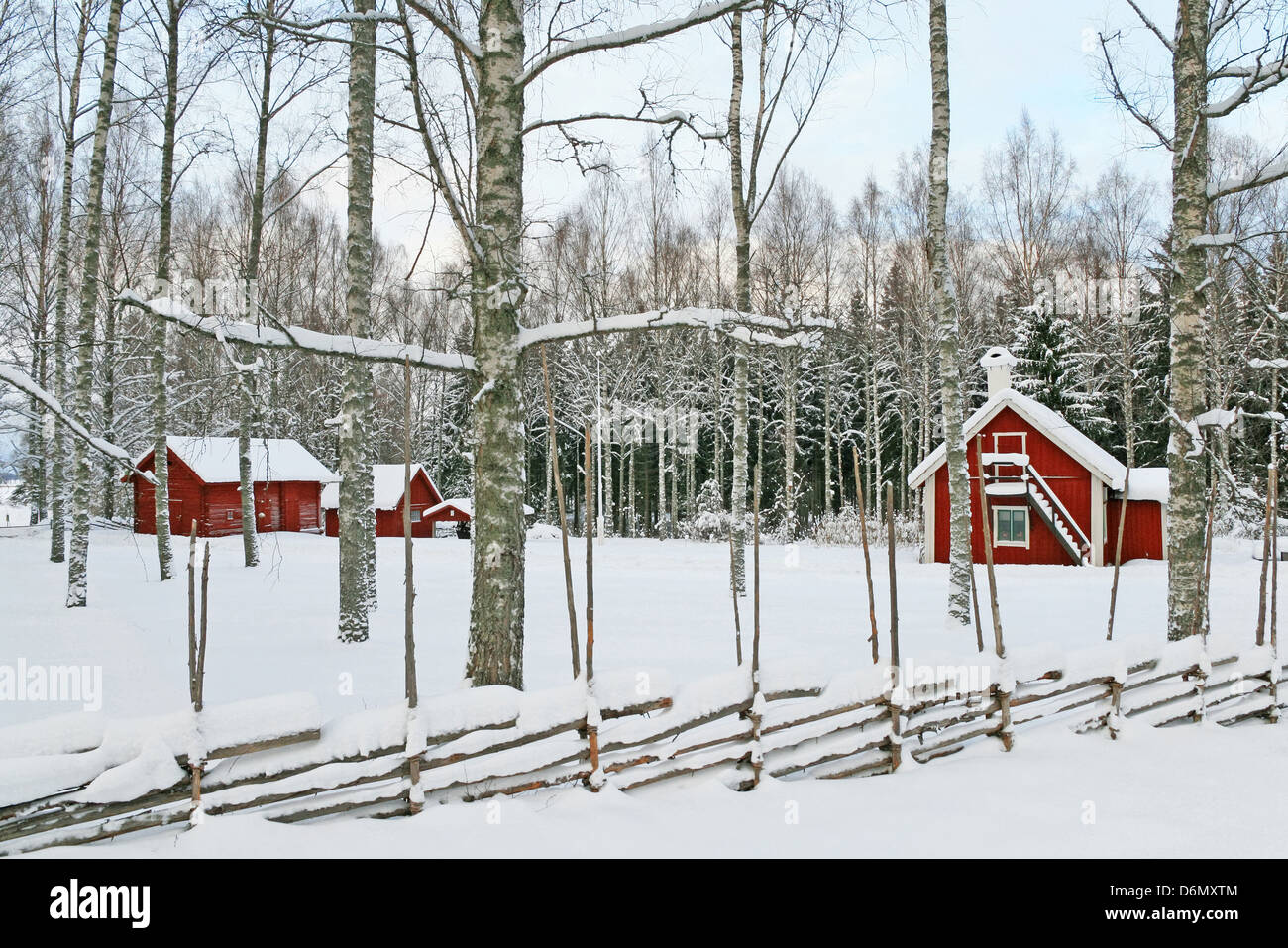 Schwedische Winterlandschaft mit traditionellen roten Holzhäusern mit Schnee bedeckt. Stockfoto