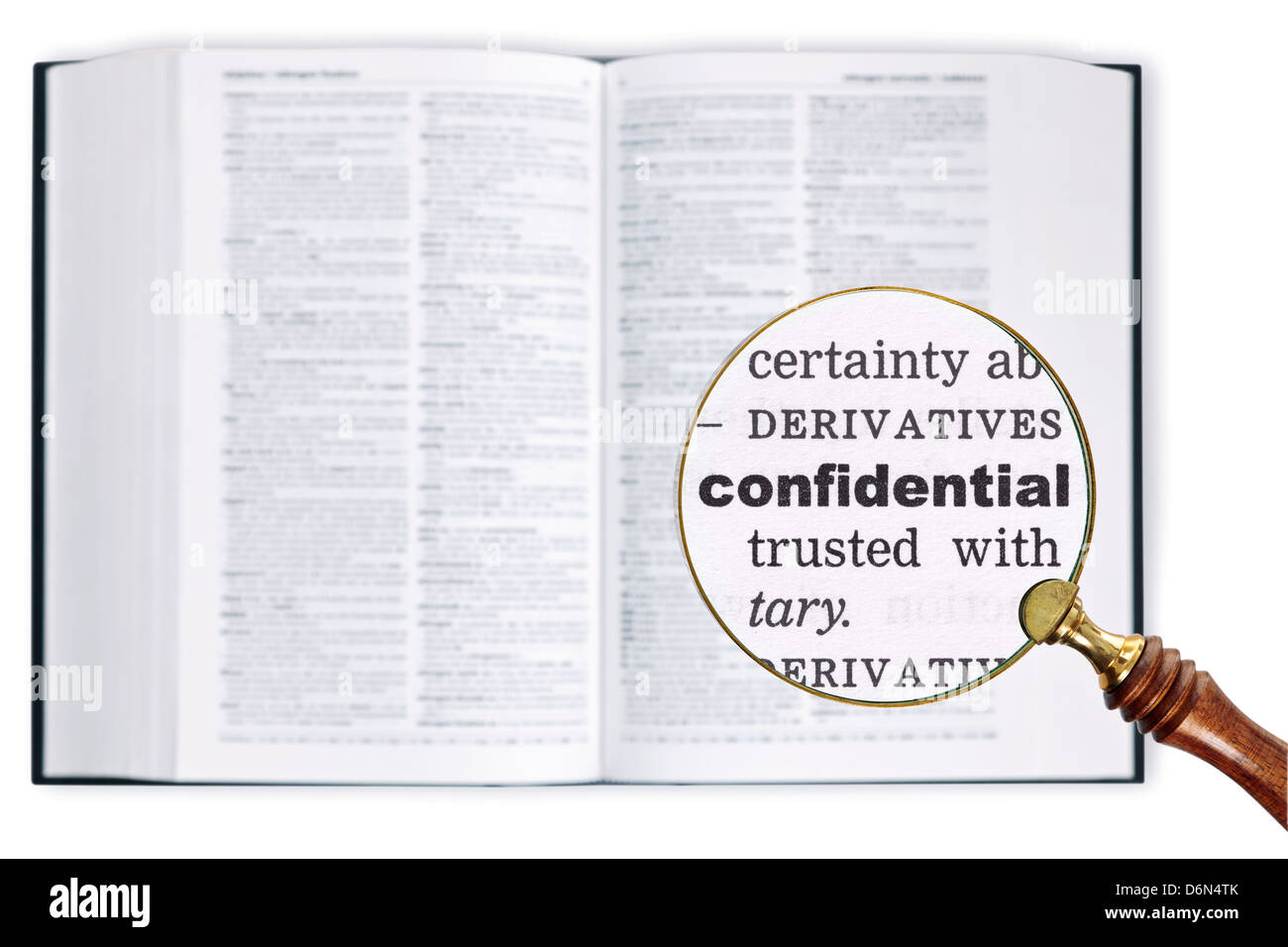 Vergrößert eine Lupe über ein Wörterbuch das Wort vertraulich betrachten gehalten Stockfoto