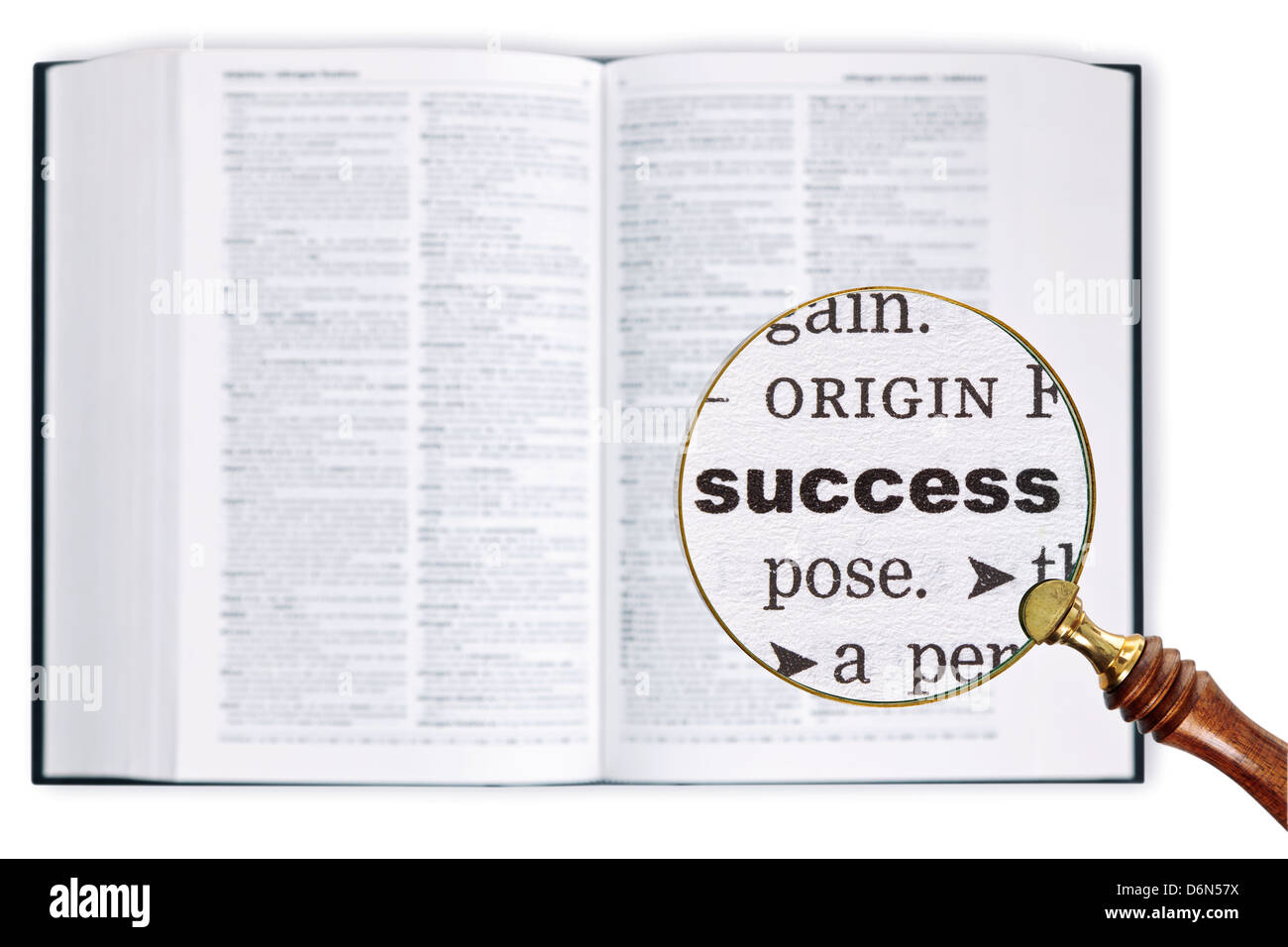 Vergrößert eine Lupe über ein Wörterbuch das Wort Erfolg betrachten gehalten Stockfoto