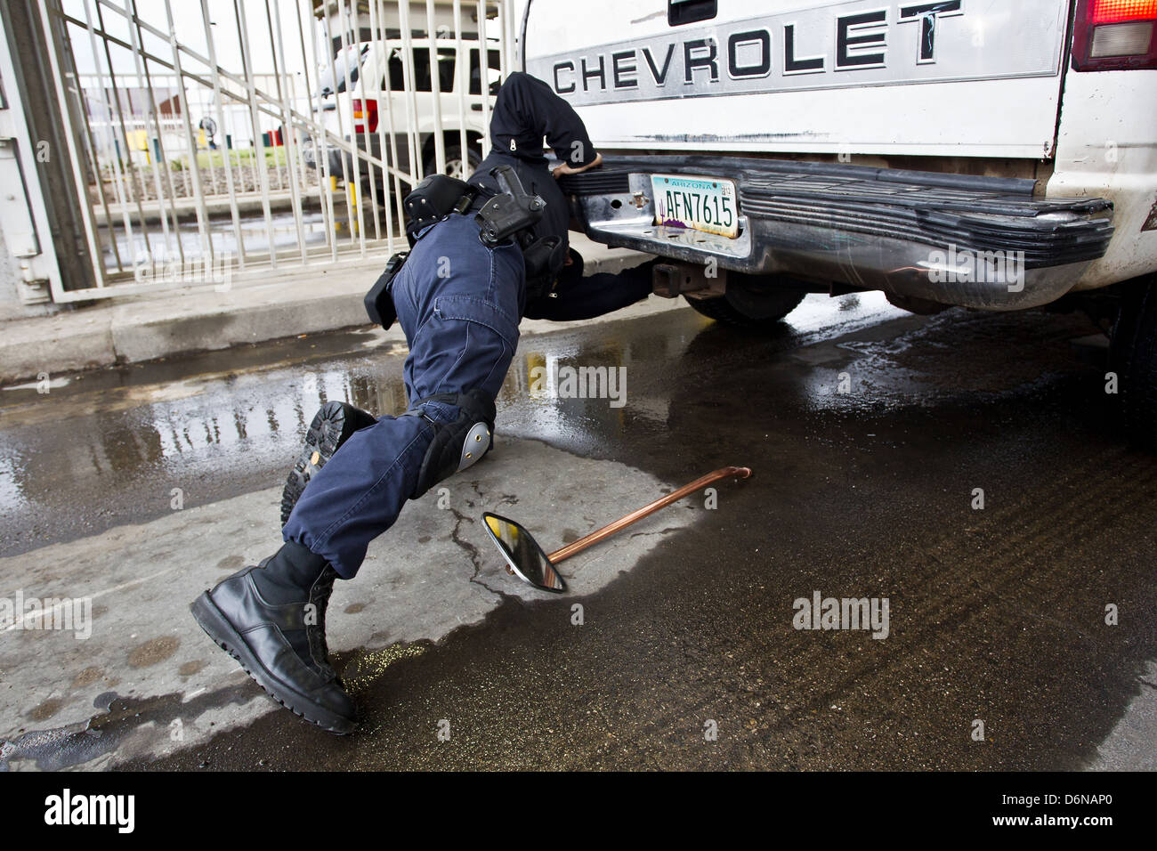 Ein US Customs and Border Protection Officer inspiziert ein Fahrzeug für Schmuggelware am Grenzübergang San Luis 16. Februar 2012 in San Luis, AZ. Stockfoto