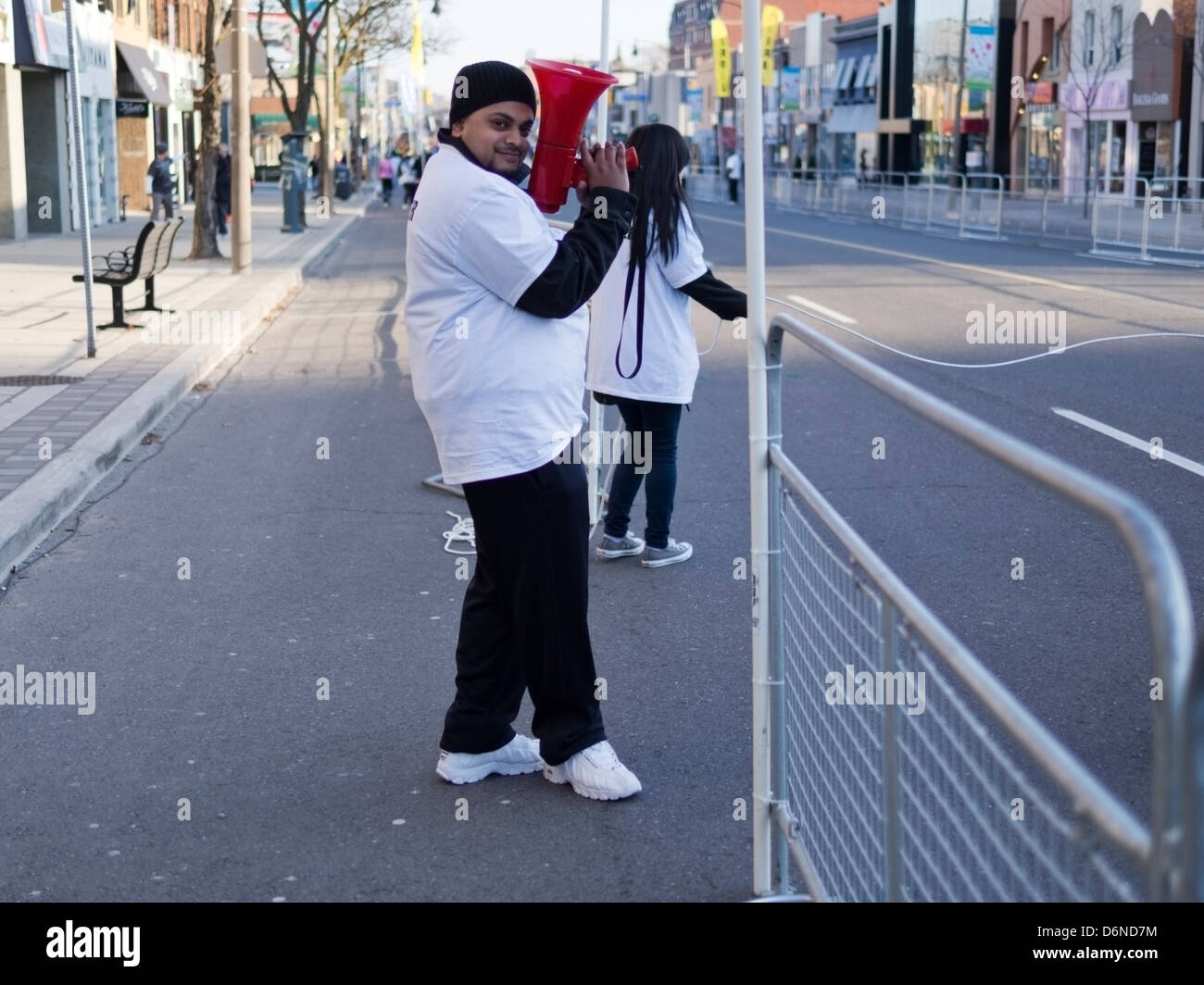 Ein Freiwilliger in einem weißen T-shirt schwingt einen rotes Megaphon Lautsprecher im 2013 Toronto Yonge Street 10K laufen Stockfoto
