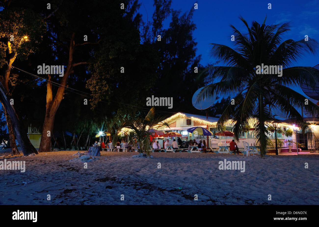 Holetown, Barbados, die Gäste sitzen am Abend vor dem beleuchteten Surfside Restaurant Stockfoto