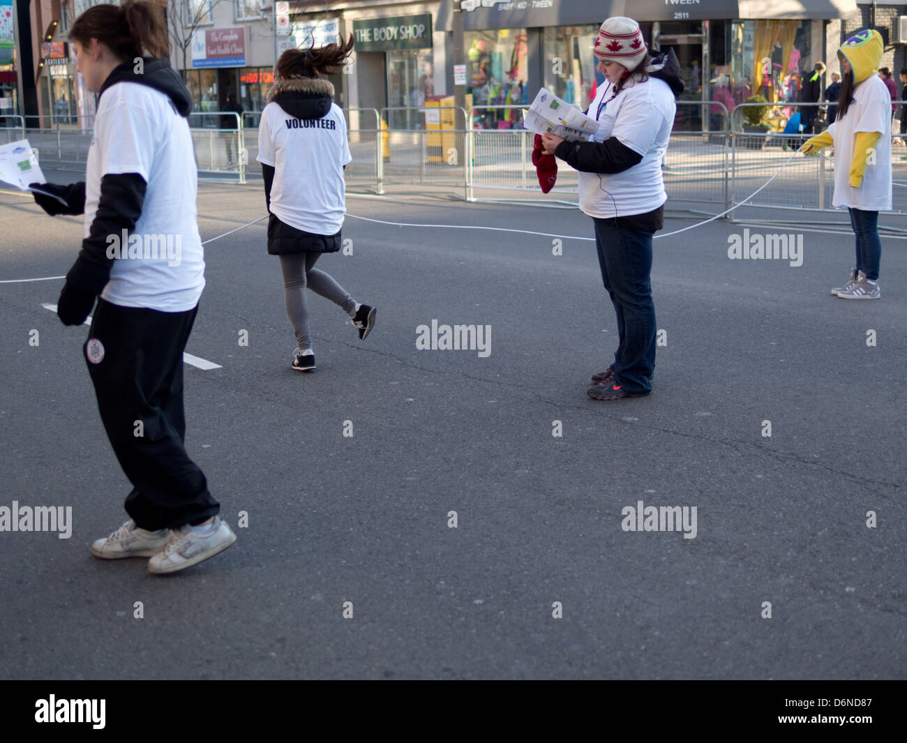 Freiwillige in weißen T-shirts warten zum Jahresbeginn die 2013 Toronto Yonge Street 10K laufen Stockfoto