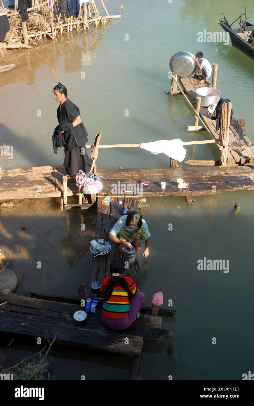 Burmesische Dorfbewohner waschen im Fluss nach einer Mahlzeit Stockfoto