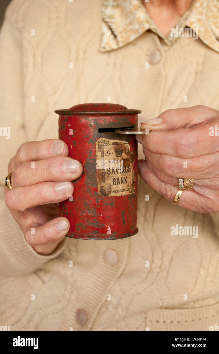 Ältere Frau misshandelte Spardose fünfzig Pence Inbetriebnahme Stockfoto