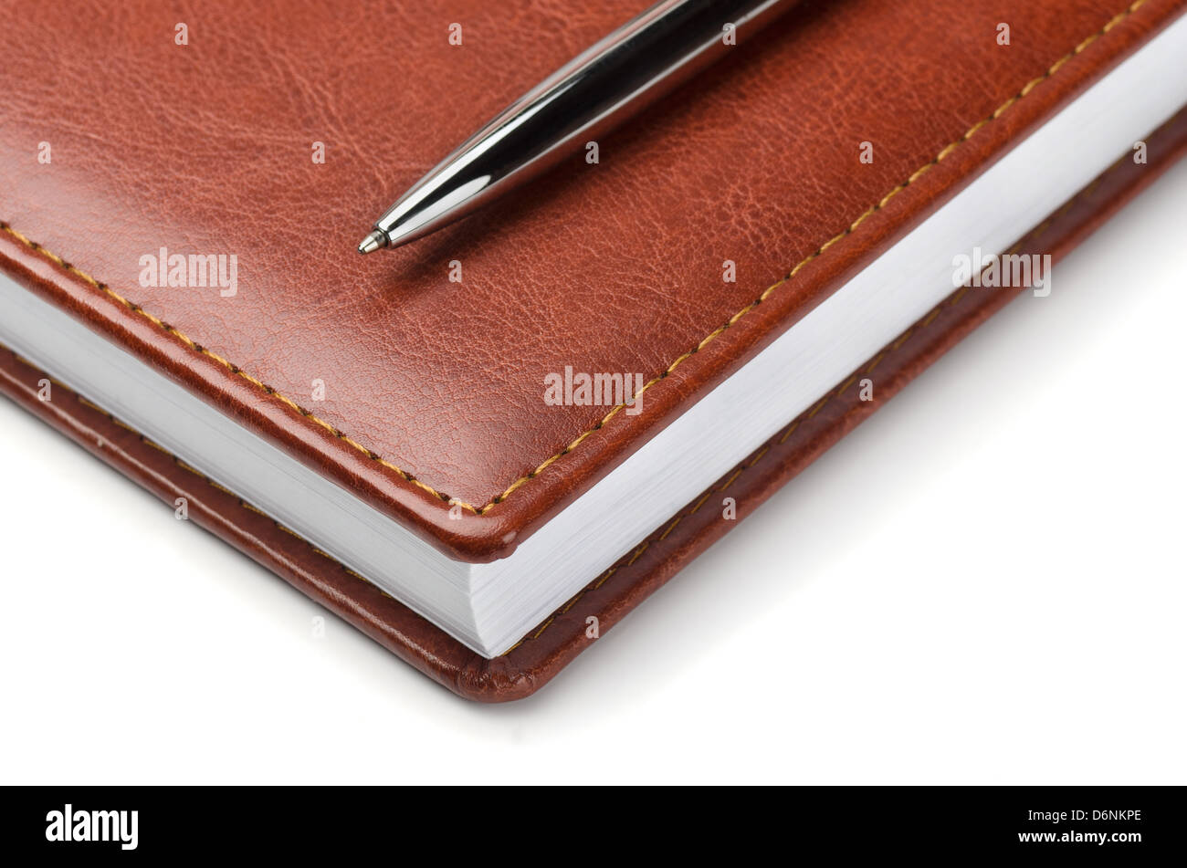 Braune Leder-Notizbuch mit Stift auf weißem Stockfoto
