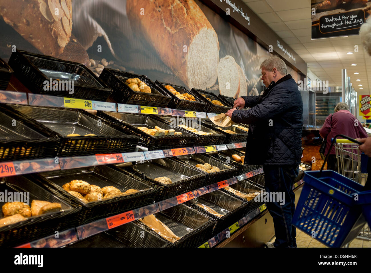 Ein Mann Auswahl frisch gebackenes Brot und andere Gegenstände aus der Bäckerei-Anzeige in Lidls Supermarkt, Aberystwyth UK Stockfoto