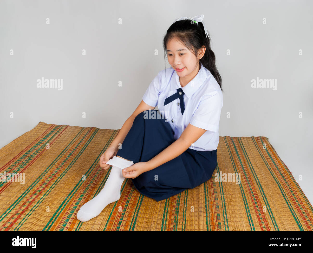 Fröhlich asiatisch Thai Gymnasiast ist ihre Socken Falten. Stockfoto