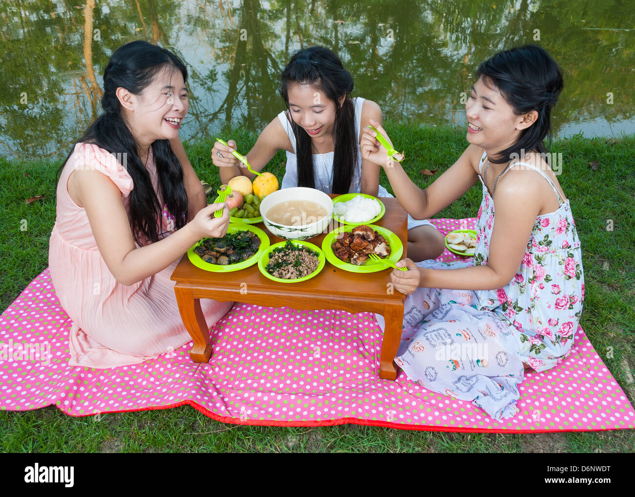 Asiatische Thaigirls Picknick neben Sumpf zusammen. Stockfoto