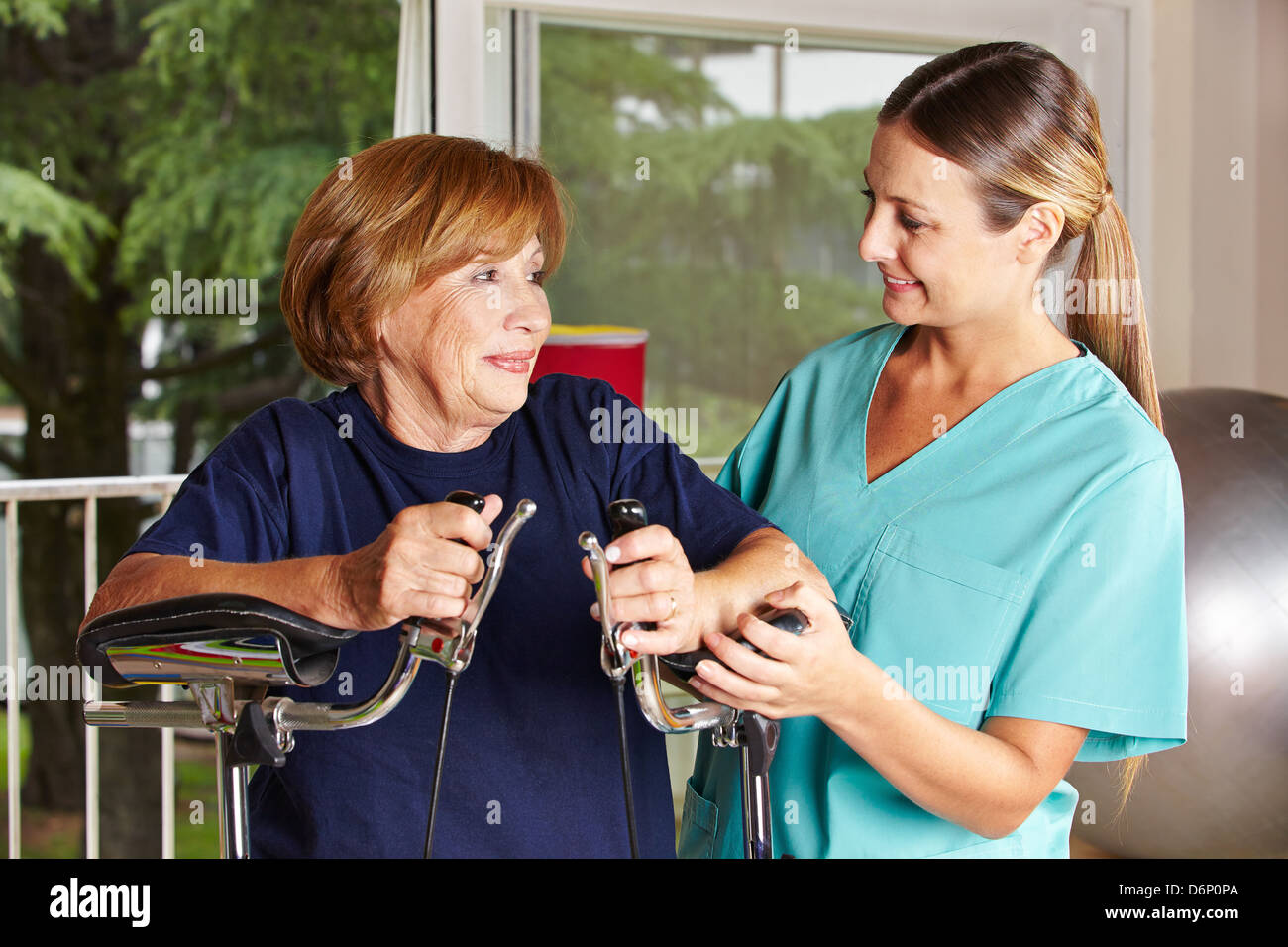 Krankenschwester hilft älteren Frau in der Reha in einer Physiotherapie Stockfoto