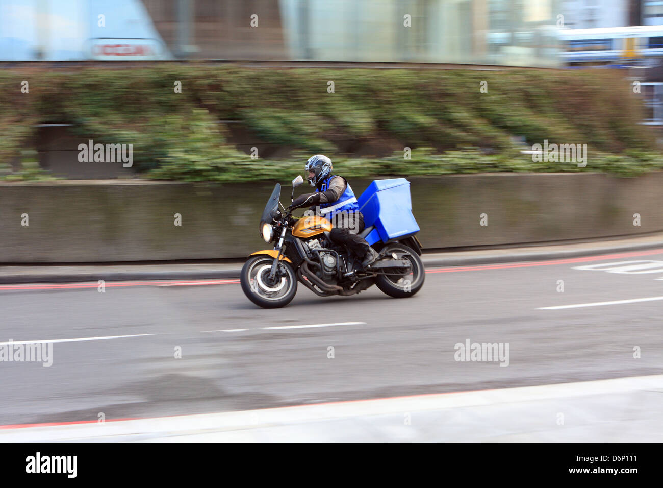 Ein Motorradfahrer, um einen Kreisverkehr in London, England reisen. Stockfoto