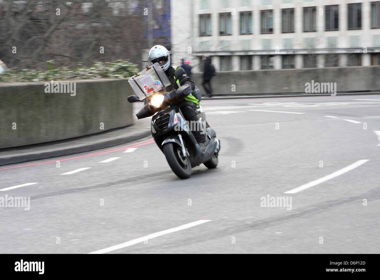 Ein Motorradfahrer, um einen Kreisverkehr in London, England reisen. Stockfoto