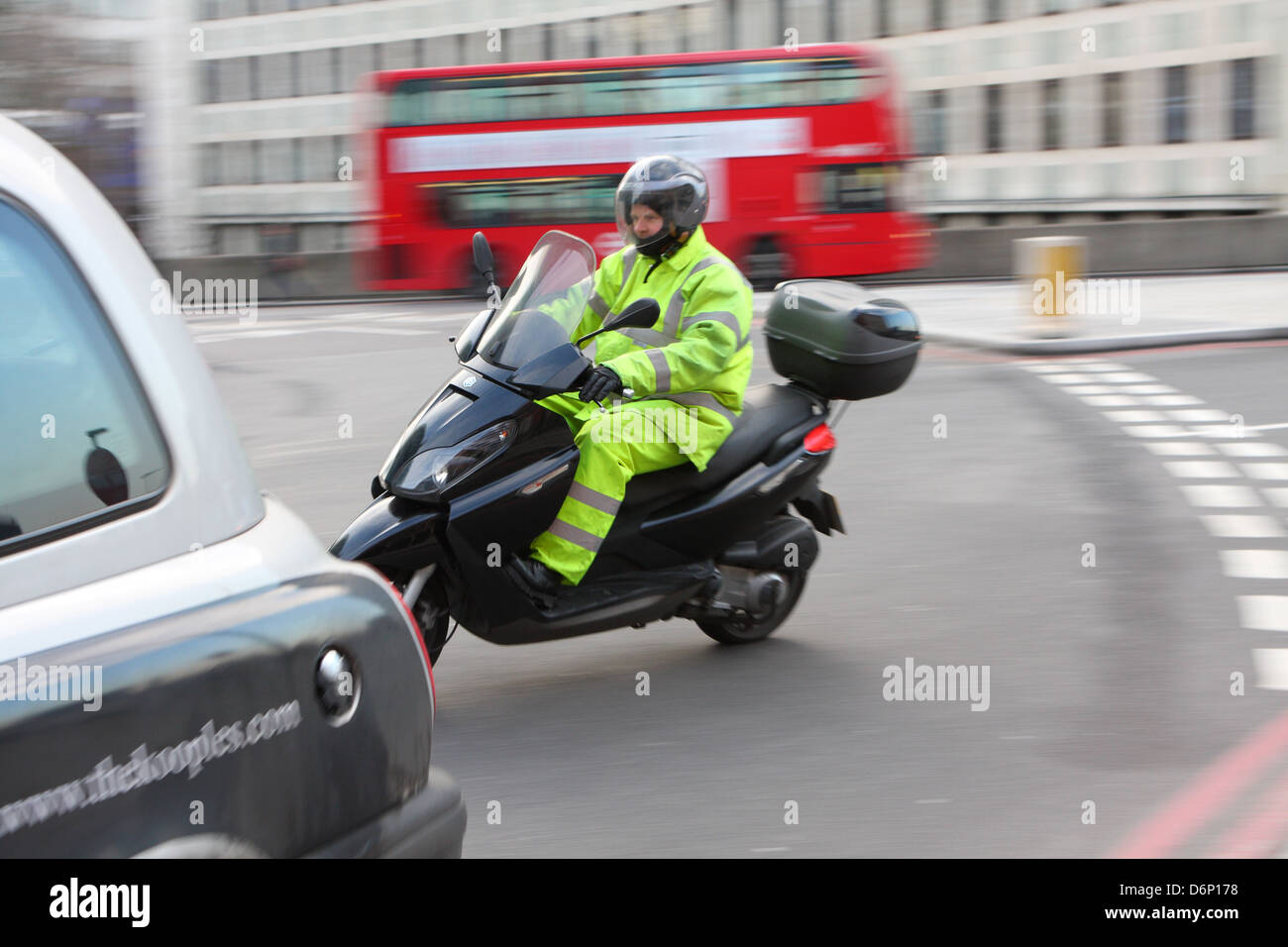 Ein Motorradfahrer und ein Teil eines Taxis in einem Kreisverkehr in London, England. Stockfoto