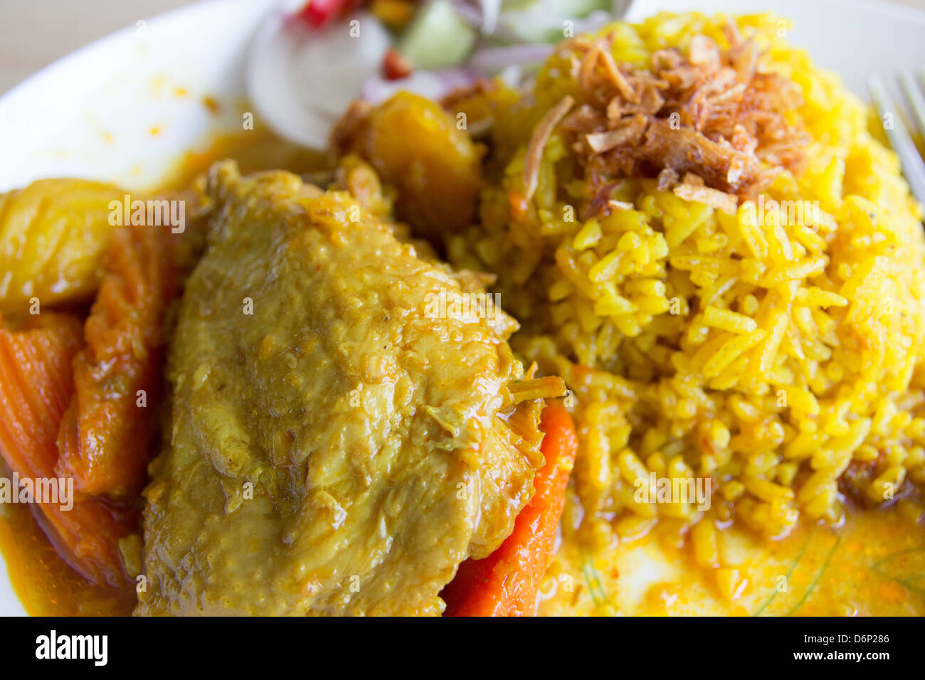 Chickencurry mit gelbem Reis Stockfoto