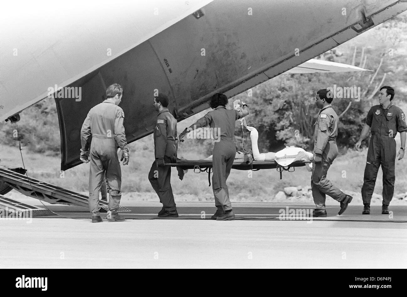 US Air Force Piloten evakuieren einen verwundeten Soldat zu einem wartenden c-141 Flugzeugen während der Invasion von Grenada, unter dem Codenamen Operation Urgent Fury 1. November 1983 in St. Georges, Grenada. Die Invasion begann am 25. Oktober 1983 und wurde die erste größere militärische Aktion von den Vereinigten Staaten seit dem Ende des Vietnam-Krieges. Stockfoto