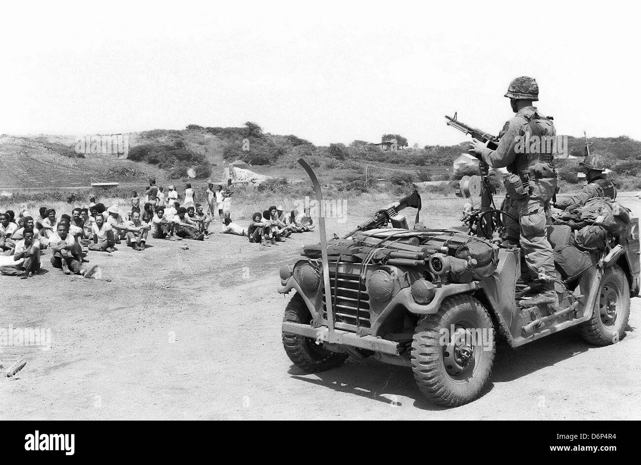 US-Marines bewachen aufgenommene Mitglied der Völker revolutionäre Armee während der Invasion von Grenada, unter dem Codenamen Operation Urgent Fury 25. Oktober 1983 in St. Georges, Grenada. Die Invasion begann am 25. Oktober 1983 und wurde die erste größere militärische Aktion von den Vereinigten Staaten seit dem Ende des Vietnam-Krieges. Stockfoto
