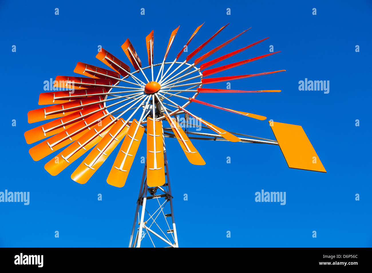 Nahaufnahme von einer Orange Windmühle vor einem strahlend blauen Himmel Stockfoto