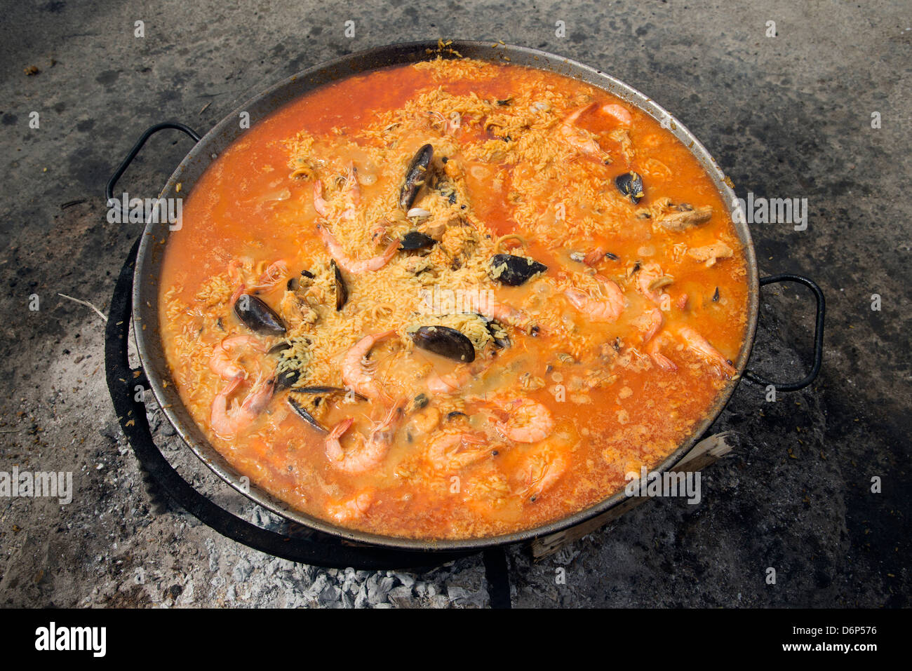 Spanische Paella Kochen in einer Pfanne auf heiße Glut Stockfoto