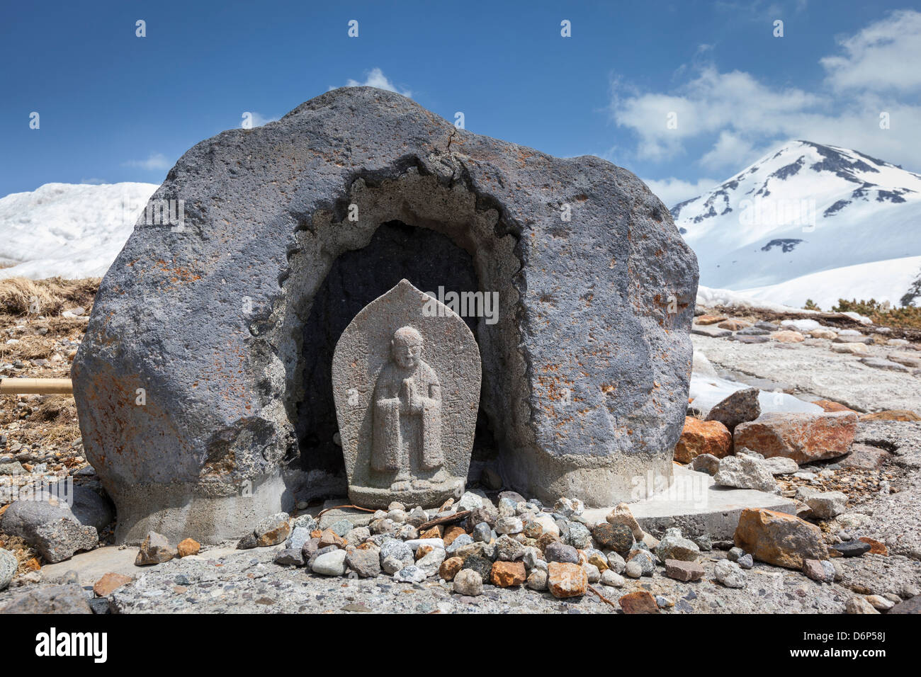 Eine kleine buddhistische Statue in einer Nische in einem großen Stein Felsbrocken liegt am Tateyama Berg der japanischen Nordalpen geschnitten. Stockfoto